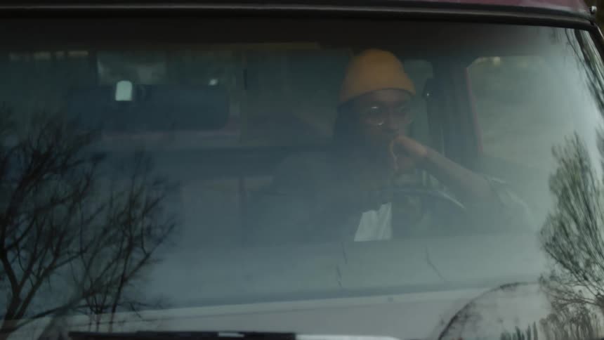 A woman is driving a vehicle during the daytime