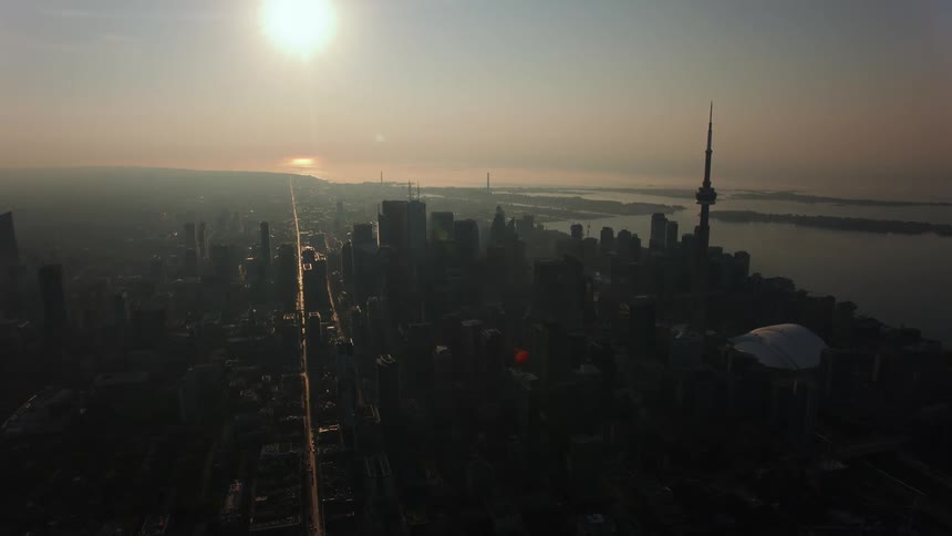 Bright sunlight shines down on a dense city along the coast