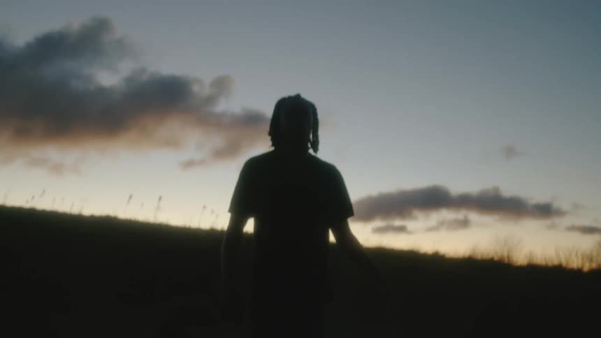 A man appears lost and confused while wandering through a field
