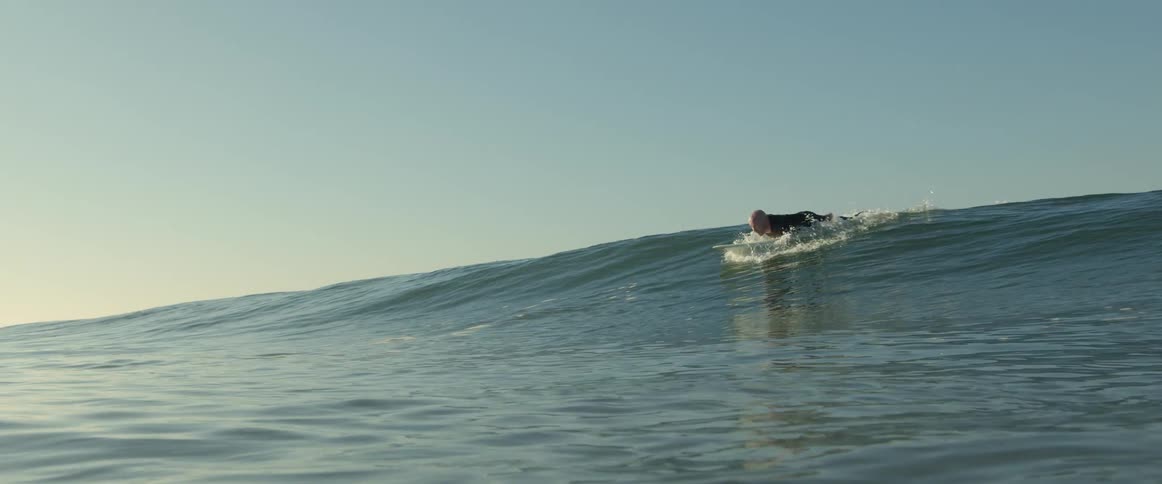 A man is riding a surfboard on a wave