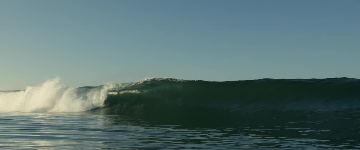 A very large wave rolls over as it moves