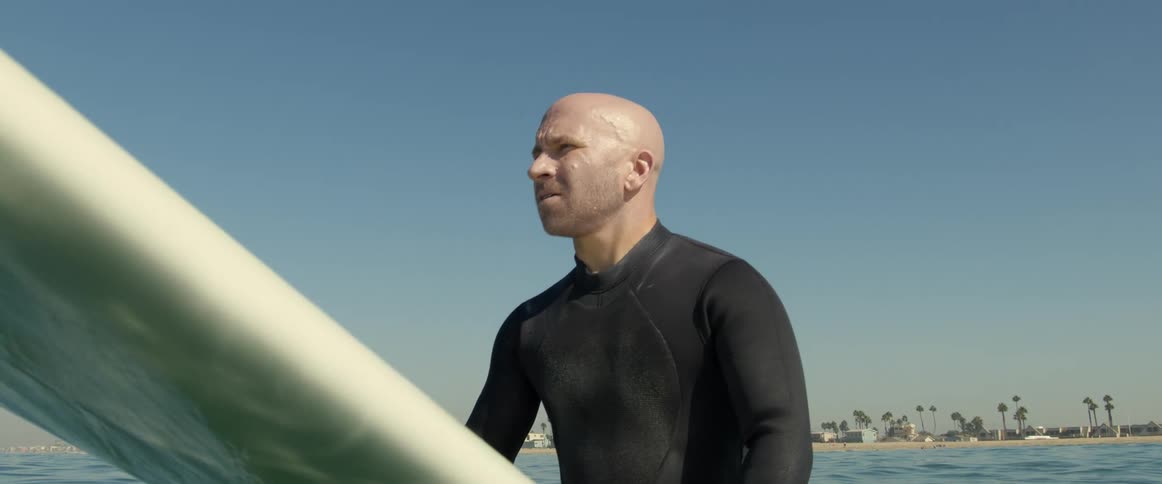 A man sitting on a surfboard outdoors