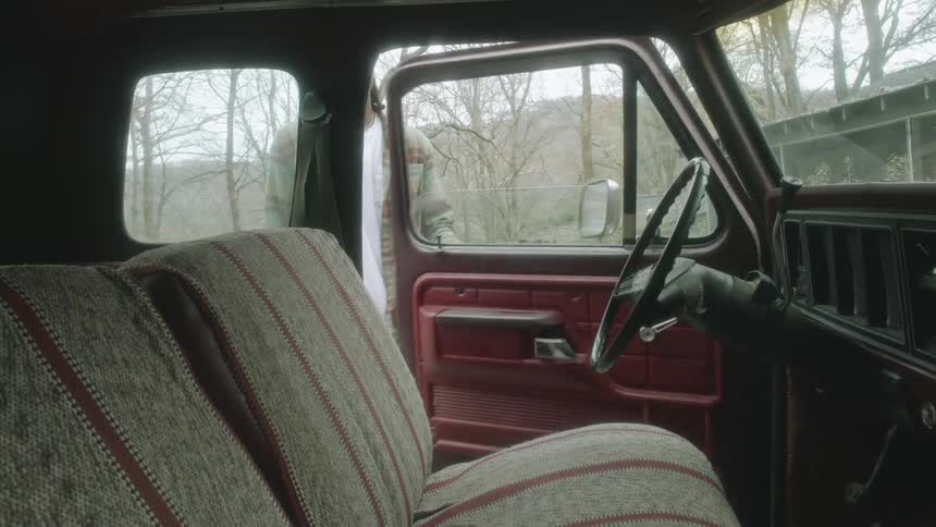 A man sitting down in a truck outdoors