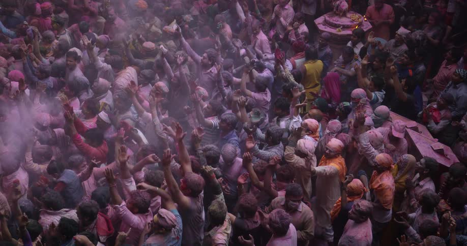 A crowd of people dancing in colored powder