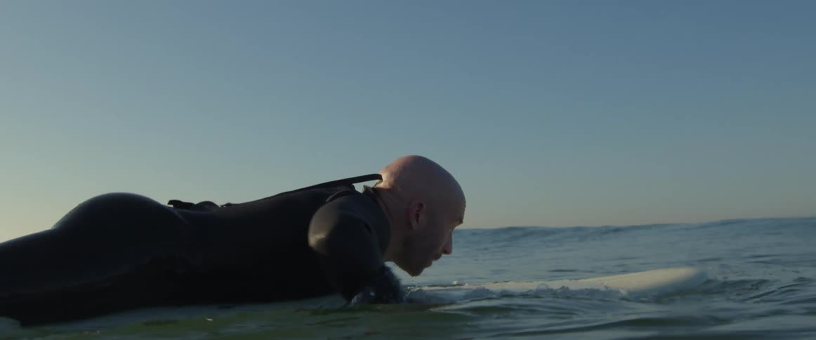 A man is surfing outdoors in the ocean water