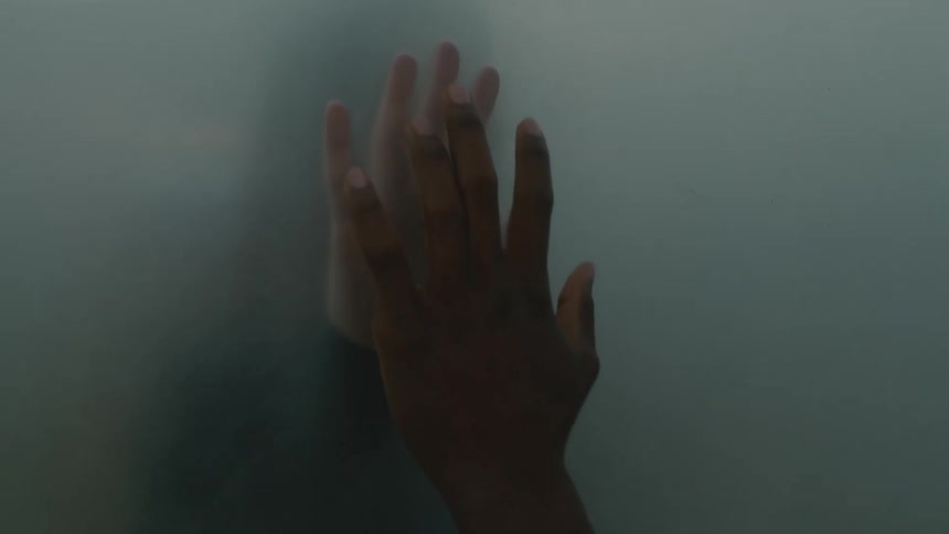 Two peoples hands are touching each out surrounded by some fog