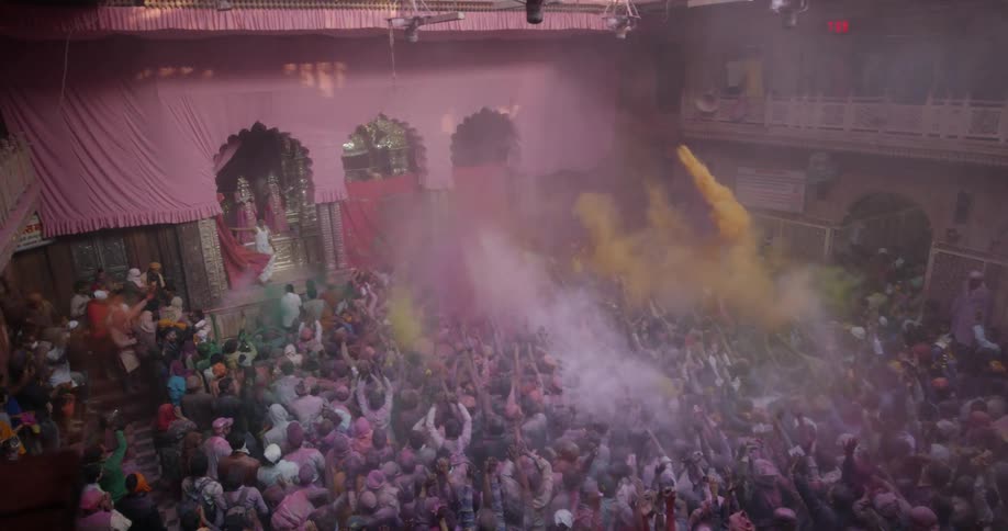 A group of people throw colored powder