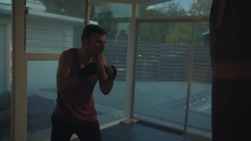 A man is throwing punches at a punching bag