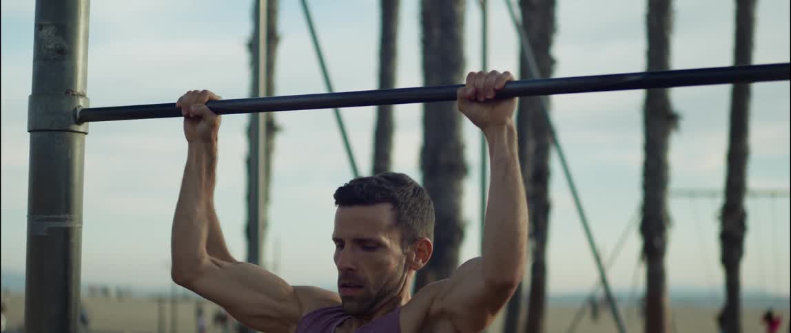 A young man is working out outdoors in the middle of the day