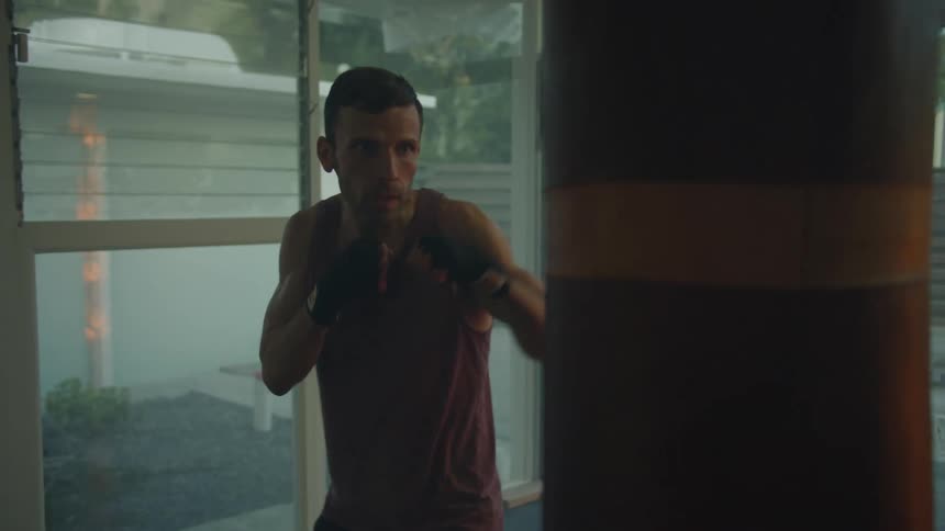 A man is boxing and exercising indoors