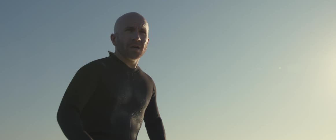 A man sitting on his surfboard in the ocean