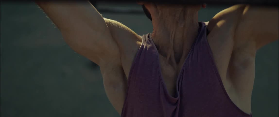 A man pulls himself up on monkey bars at a park