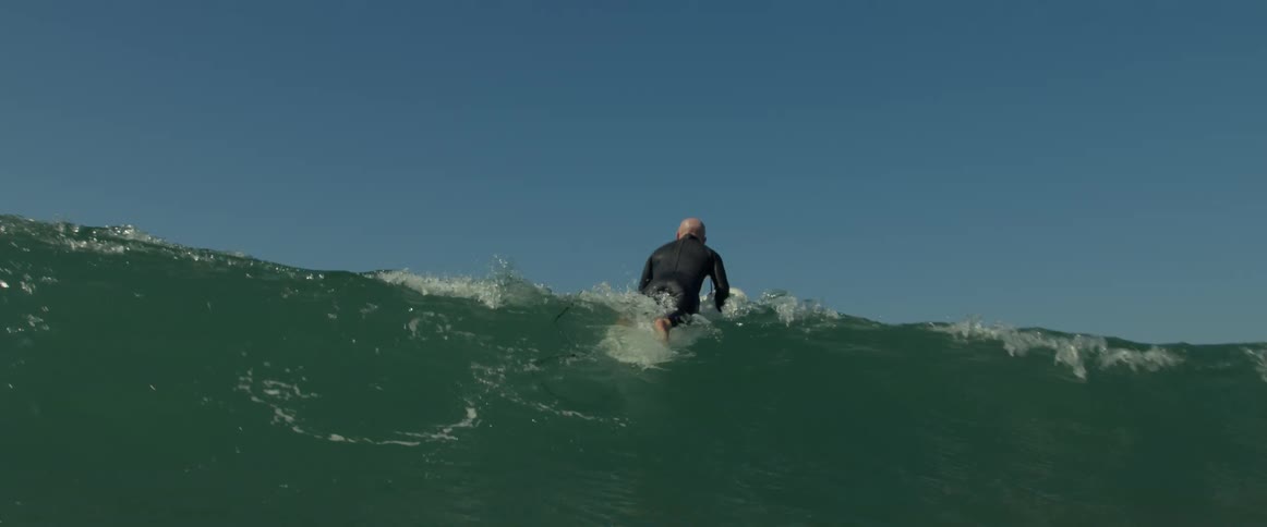 A man is surfing on the ocean water