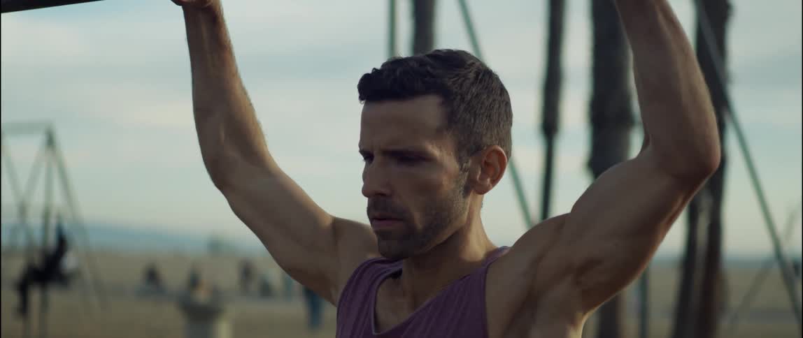 A young man is working out outdoors in the middle of the day