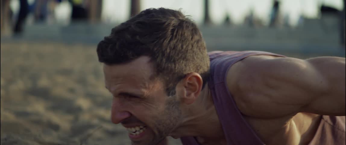 A man is exercising on the beach outdoors