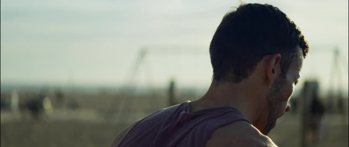 A man exhales as he bends to stretch out before running at the park