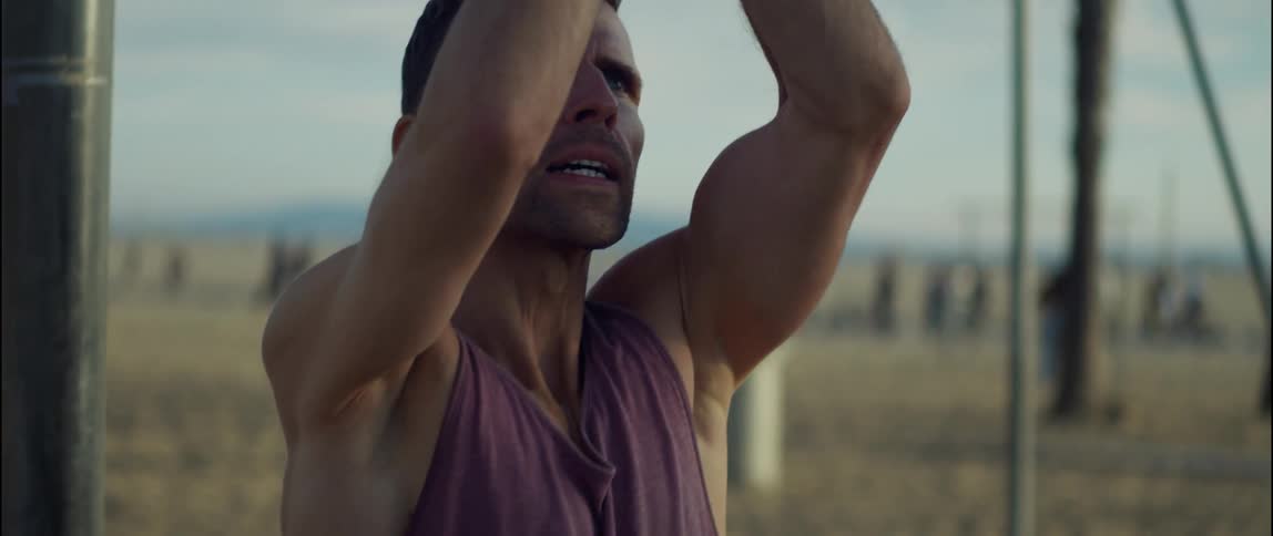 A man exercises using equipment on a beach during the day