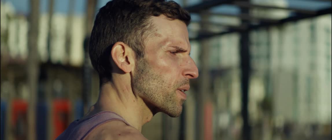A man looks in the distance while walking through a playground