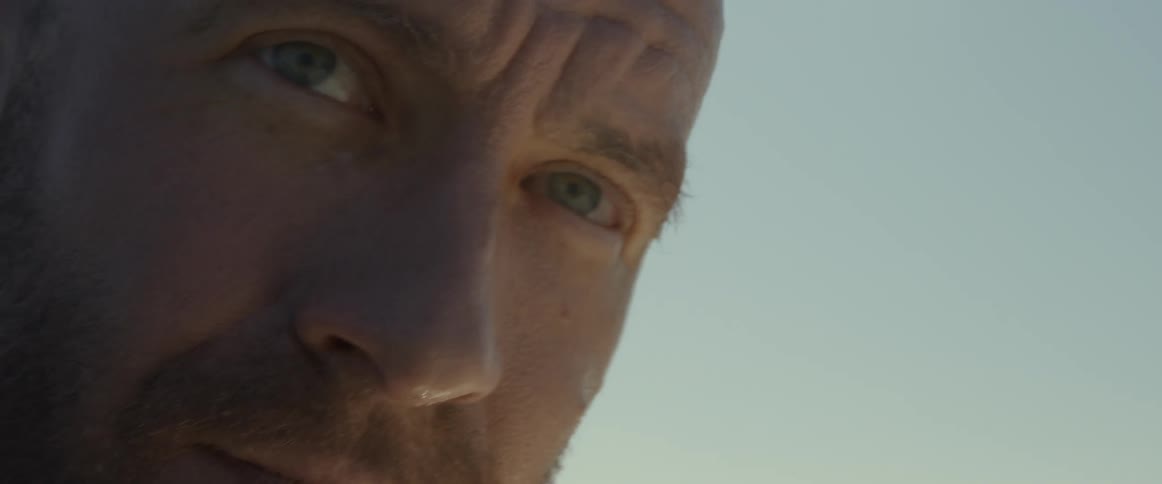 A man squinting with furrowed brow on a sunny day