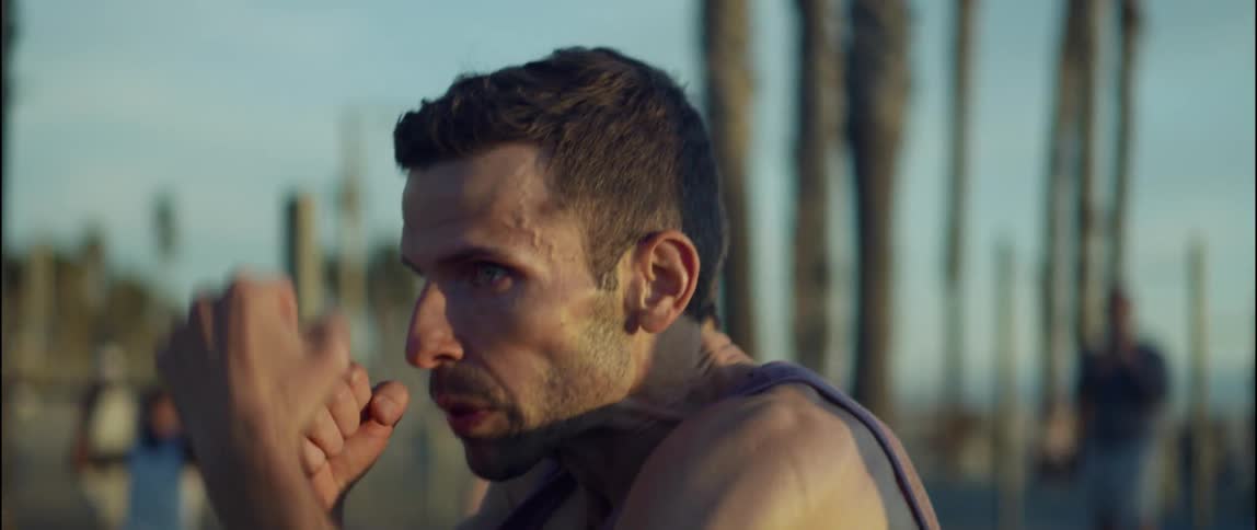 A young man is working out outdoors in the middle of the day