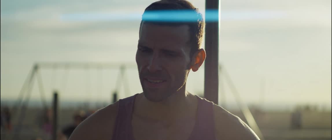 A man is standing in a playground with his hands on his hips