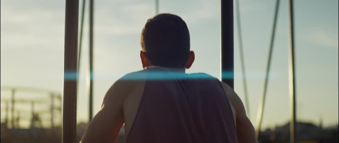 Strong young man working out on a public park in the morning