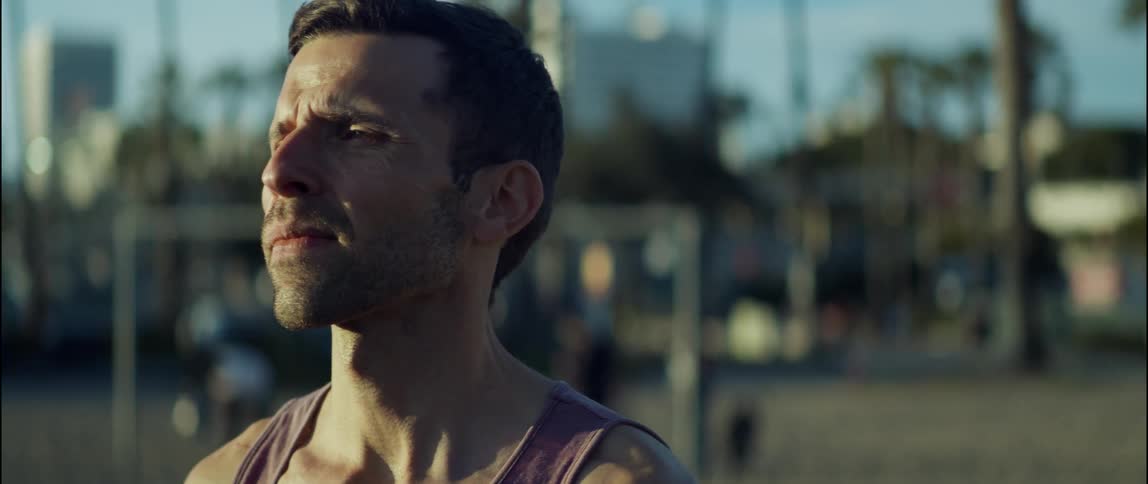 A young man is working out outdoors in the middle of the day