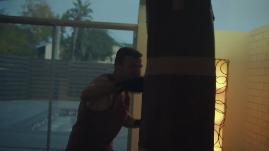 A young white man is working out indoors inside of his home