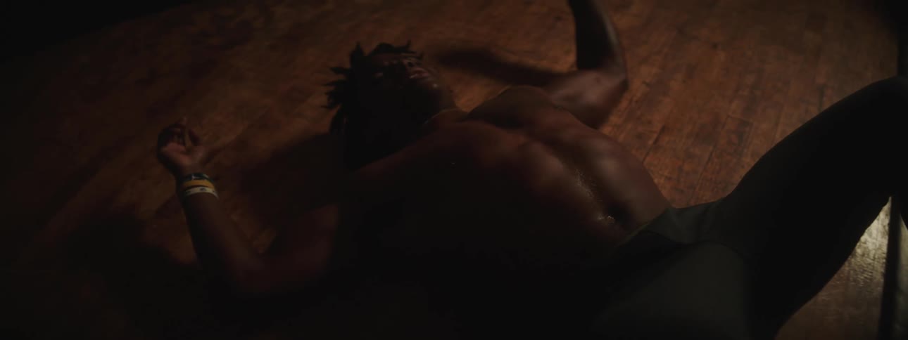 A young black man is laying on the floor after a workout