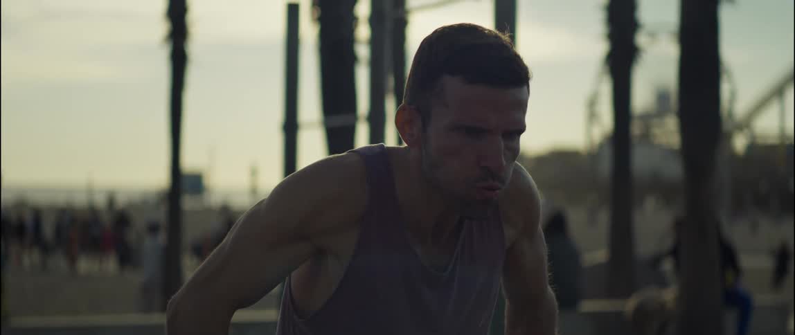 A young man is working out outdoors in the middle of the day