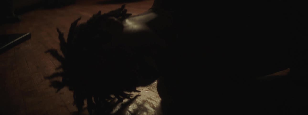 A man is covered in sweat as he rolls on a wooden floor