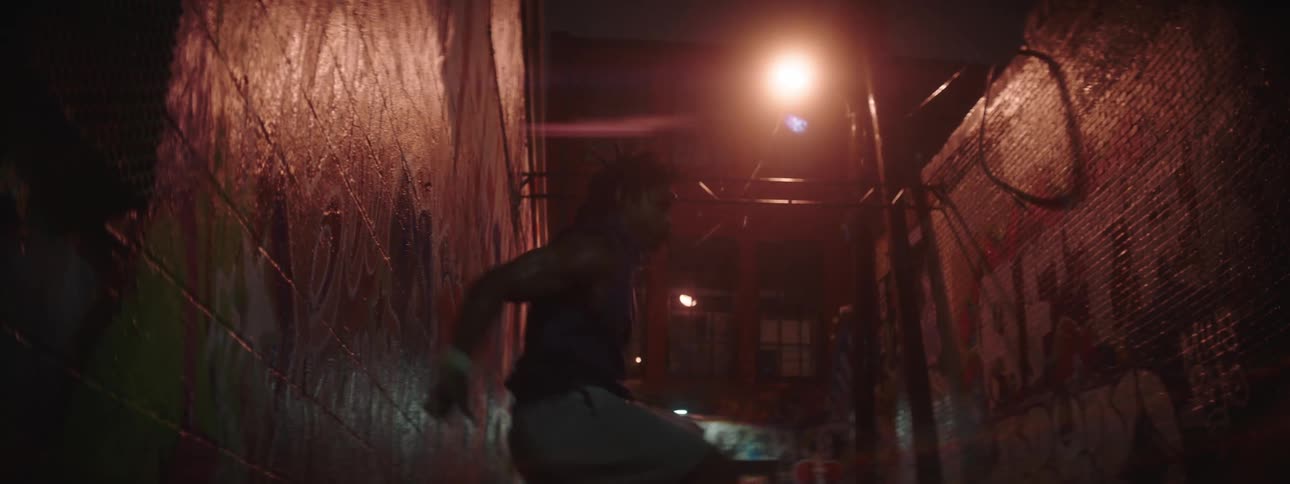 Silhouette of a strong young man working out on an alley at night