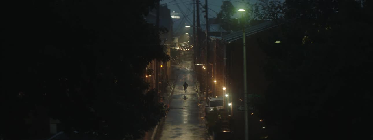 A man is running through an alley at night