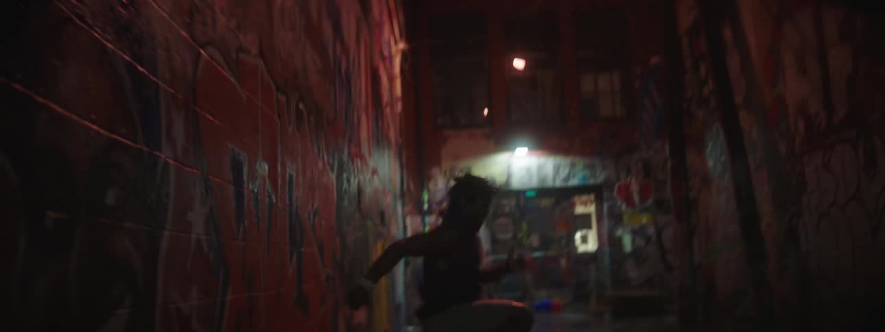 Man runs in place in alley between graffiti decorated walls