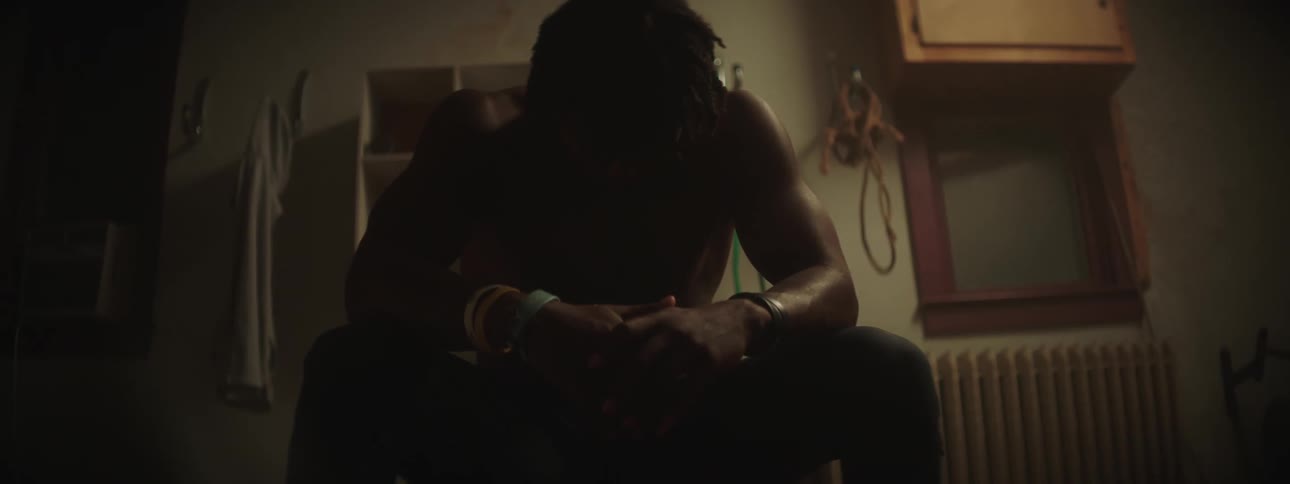 A man is sitting in a room with his head down