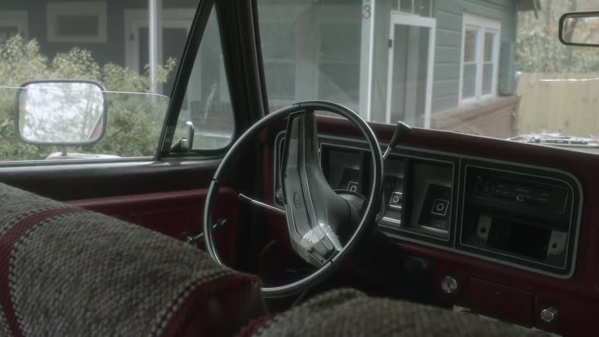 A man is walking and sits in his parked car