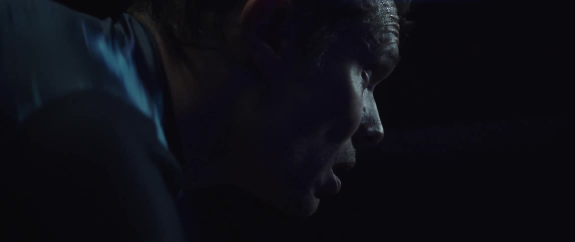 A man exhaling through his mouth while riding a stationary bike