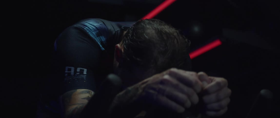 A man sweating while riding a stationary bike during an intense workout