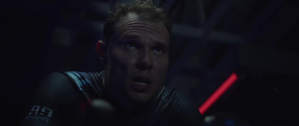 Focused sweaty man heavy breathing while exercising on a stationary bike