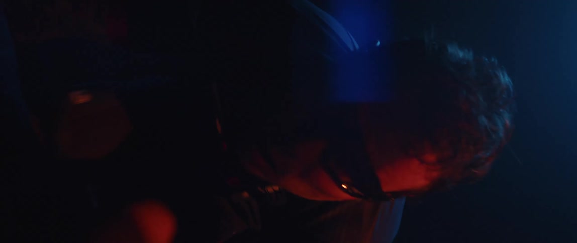 A man rides a bicycle outside at night