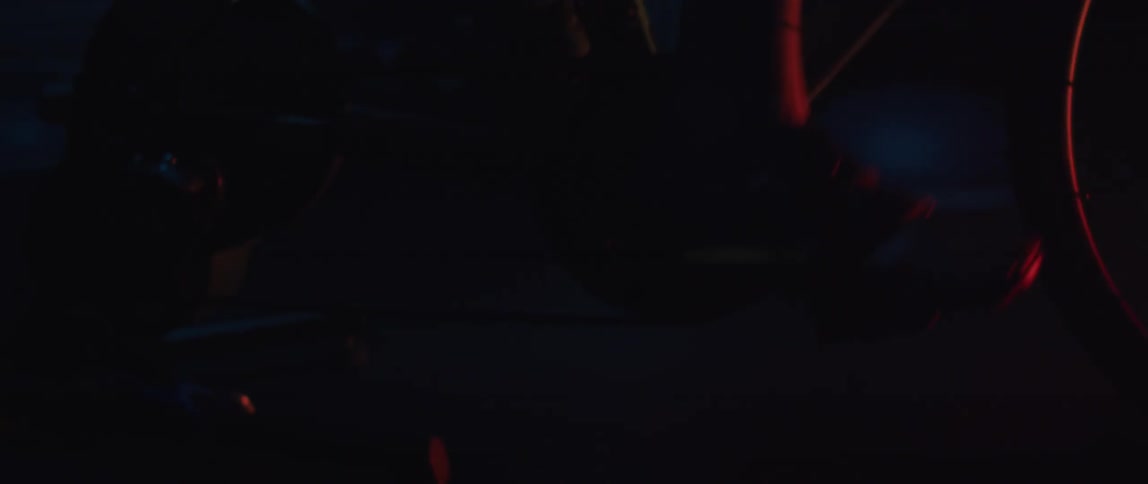 A person is pedaling a bike outdoors at night