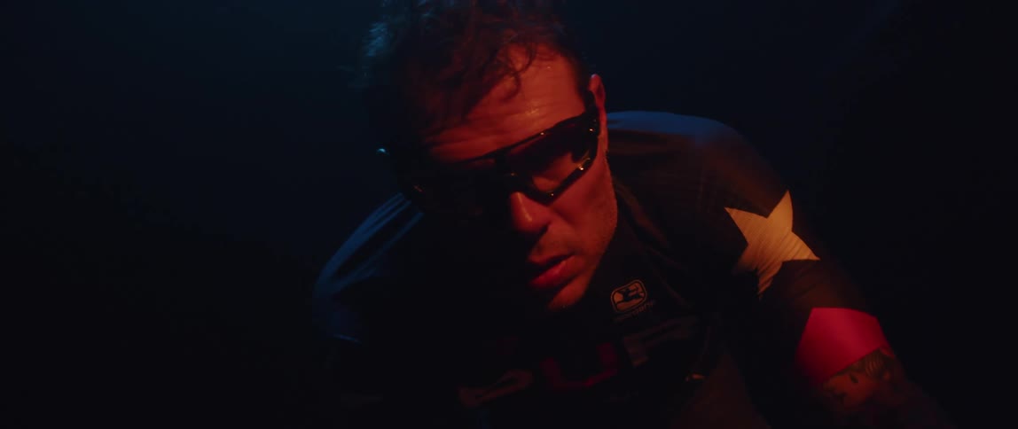 A man is pedaling in the dark