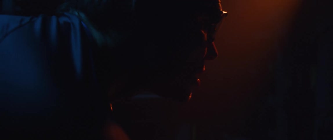 A man riding a stationary bike in a dark room