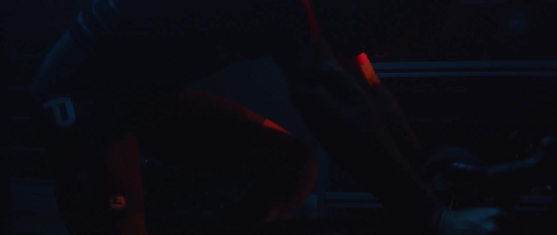 A man hunched over on a stationary bike