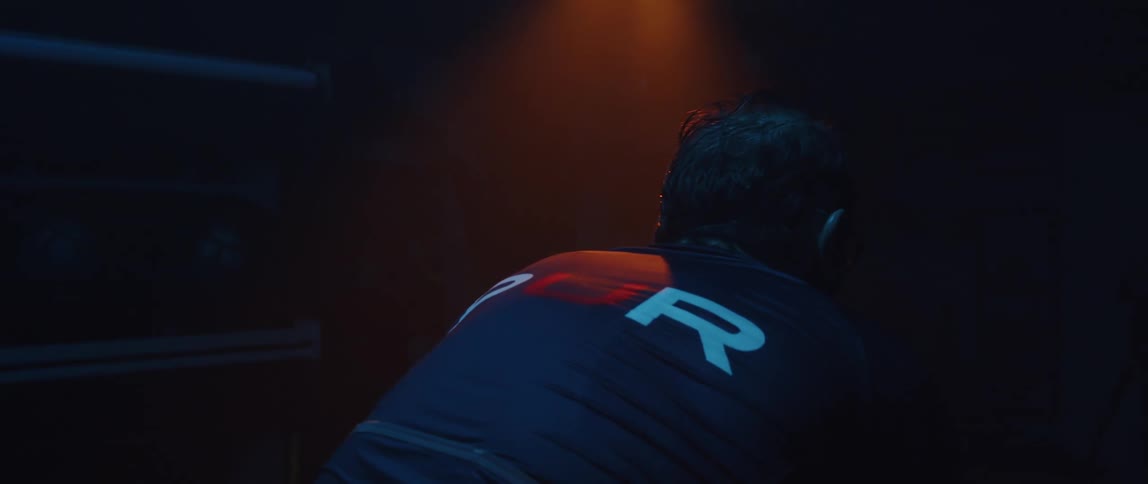 An advertisement is on a jersey worn by a man who is leaning over