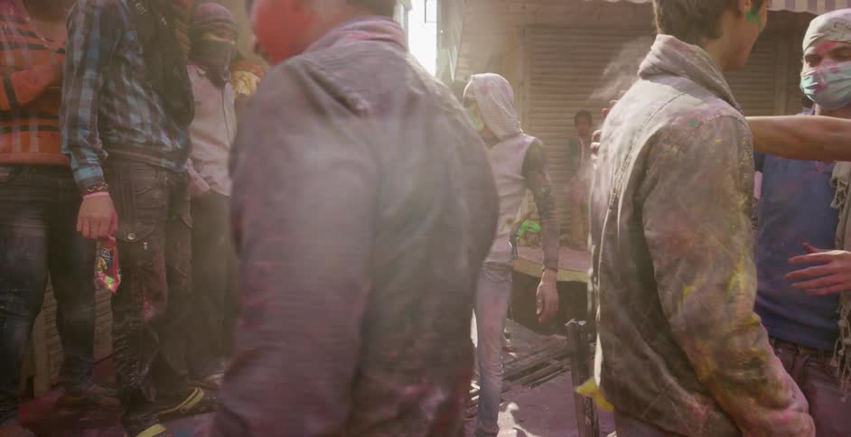People socializing while covered in dyed powder at a holi festival