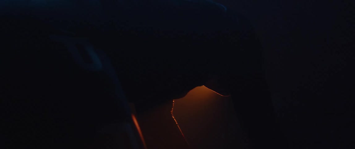 A man is seated on a bike seat as he pedals in the darkness