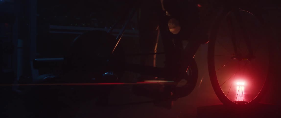 A man riding a stationary bike in a dark room