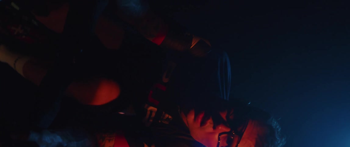 A man looks focused as he pedals on an exercise bike at night