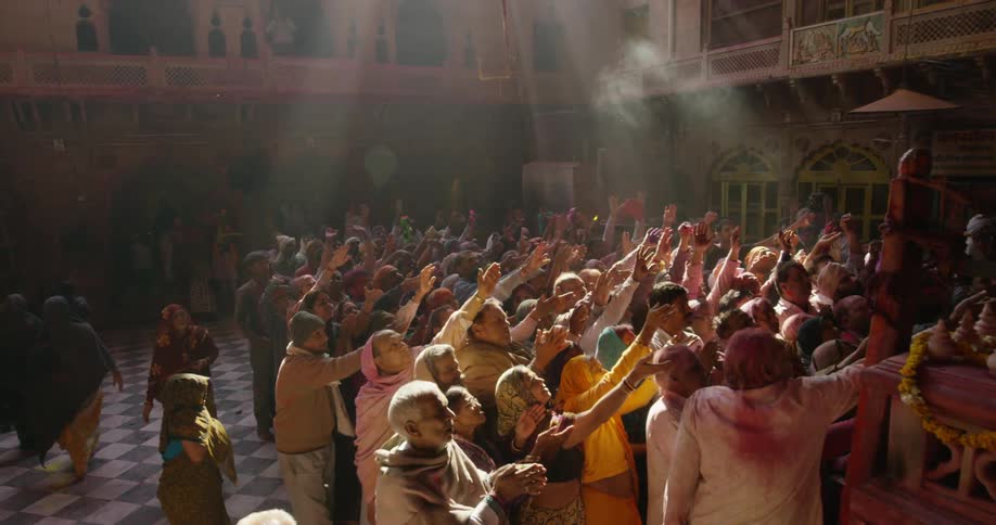 A large group of people raise their hands to the sky together